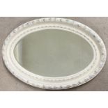 A large vintage oval shaped wall mirror with bevel edged glass. Heavy wooden frame painted white