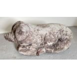 A large concrete garden ornament of a pig laying down. Approx. 23cm tall x 53cm long.