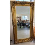 A very large & heavy rococo style gilt framed wall mirror with bevel edged glass. Approx. 184cm x