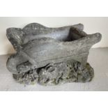 A concrete garden planter in the form of a wheelbarrow with rabbits. Approx. 29cm tall x 46cm long.