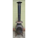 A large garden chiminea raised on tripod feet of scroll design. With repair made near door hinge.