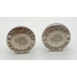 A pair of silver tone circular cufflinks by Mulberry. Mulberry name and tree logo to fronts with