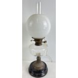 A vintage oil lamp with faceted clear glass bowl, white glass shade, chimney and stepped ceramic