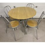 A modern circular wood effect and silver painted metal table with 4 matching chairs. Table approx.