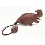 A carved wooden Oriental inro modelled as a catfish with carved mouse shaped pendant. With bone