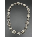 A vintage white metal pierced work oval and round link necklace each set with clear stones (some