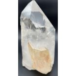 A heavy clear crystal quartz wand point with side clusters with orange/brown colour inclusions.