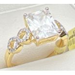 A 14kt gold plated cocktail ring set with Swarovski crystals. Central emerald cut clear stone with