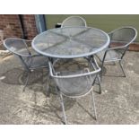 A circular shaped metal garden table with mesh top, together with 4 matching armchairs. Table has
