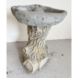 A small Cotstone concrete garden bird bath modelled as a log. With engraved verse to front of