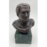 A small bronze bust mounted on a square shaped green marble base. Approx. 14cm tall.