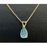 A 9ct gold and blue topaz pendant necklace. Pendant set with a teardrop cut blue topaz, on a 16"