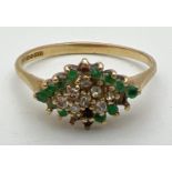A 9ct gold, emerald and diamond set dress ring. Diamond shaped mount set with small round cut