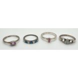 4 stone set silver dress rings in varying styles and sizes. To include blue and clear stone set