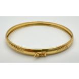 A silver gilt bangle with diamond cut criss cross pattern throughout. Push clasp and safety clip.