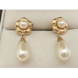 A pair of 9ct gold and faux pearl drop style earrings. A teardrop shaped faux pearl with gold cap