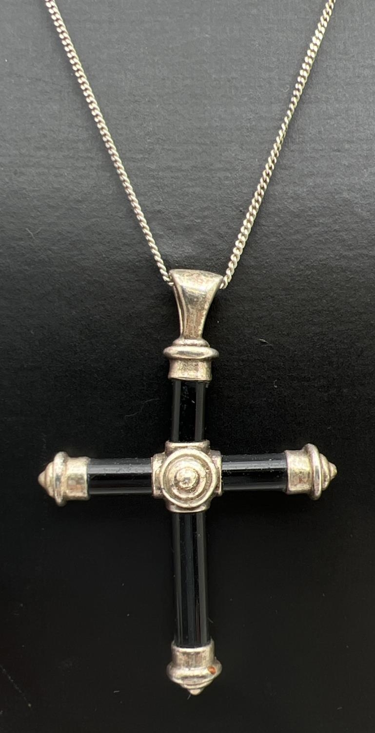 A black onyx and silver cross pendant on a 19 inch fine curb chain with spring clasp. Silver marks