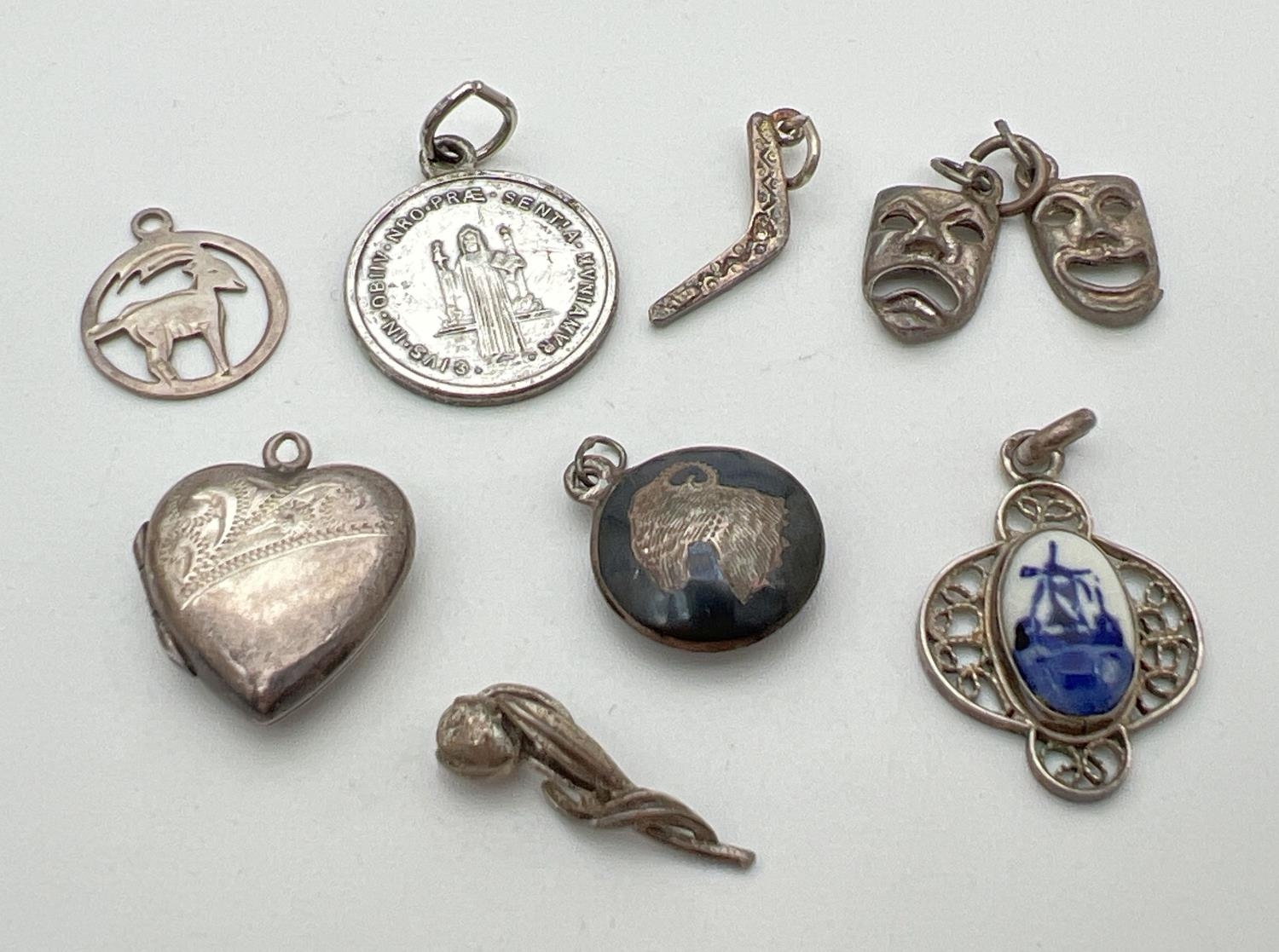 8 small silver and white metal pendants/charms. To include a heart shaped locket, Comedy and Tragedy