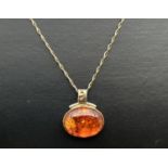 A silver and 18ct gold accent amber set oval pendant with spiral detail to bale on a 18ct gold 18