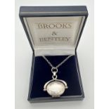 A boxed silver oval shaped spinning locket on an 18" belcher chain with spring ring clasp. Pendant