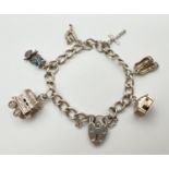 A vintage silver charm bracelet with 6 charms, padlock and safety chain. Charms comprise: Wooden