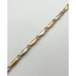 A 7.5 inch 9ct duo coloured gold bracelet with lobster claw clasp. Alternating small oval links in