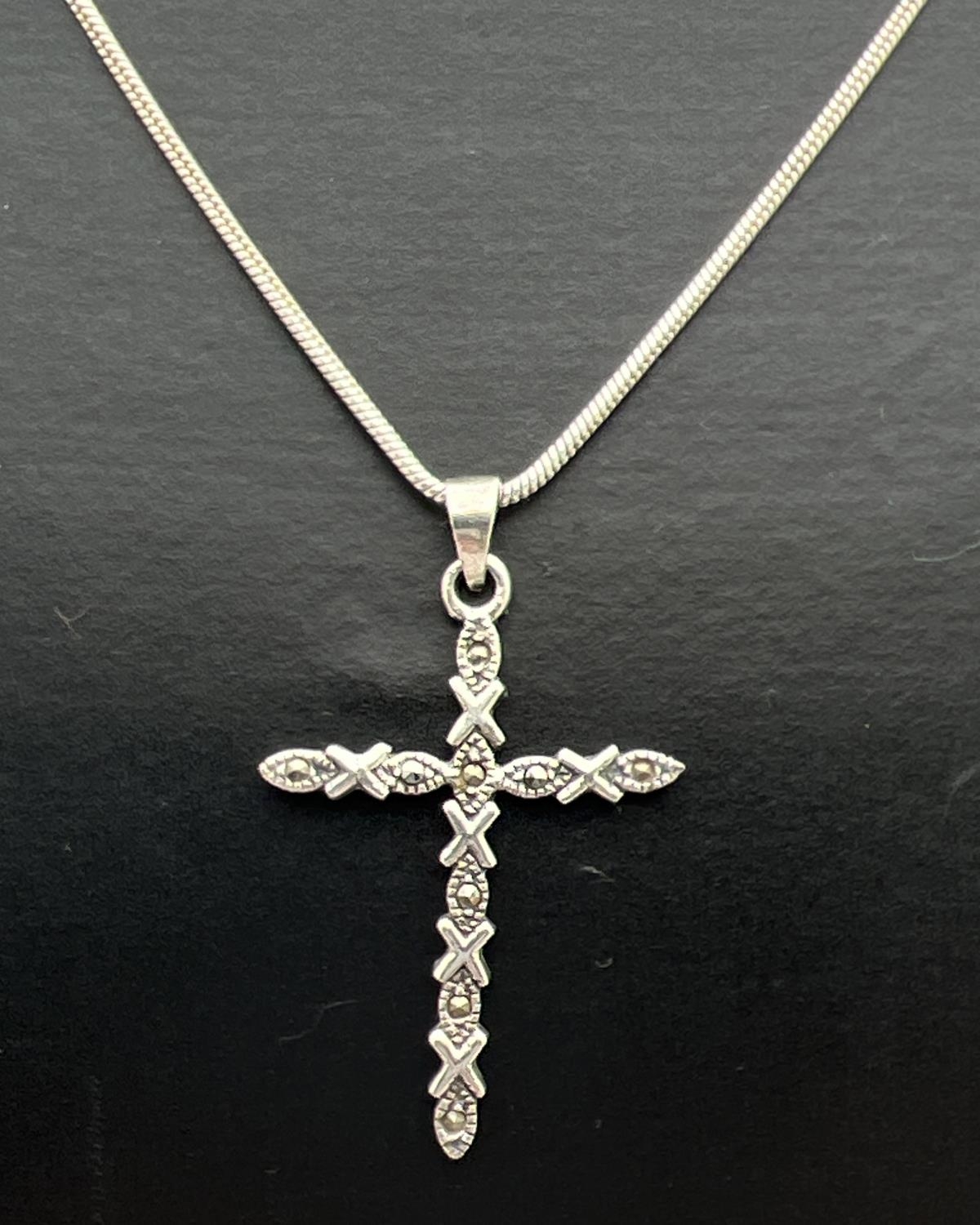 A silver cross shaped pendant set with marcasite stones, on a 17" fine snake chain with lobster claw