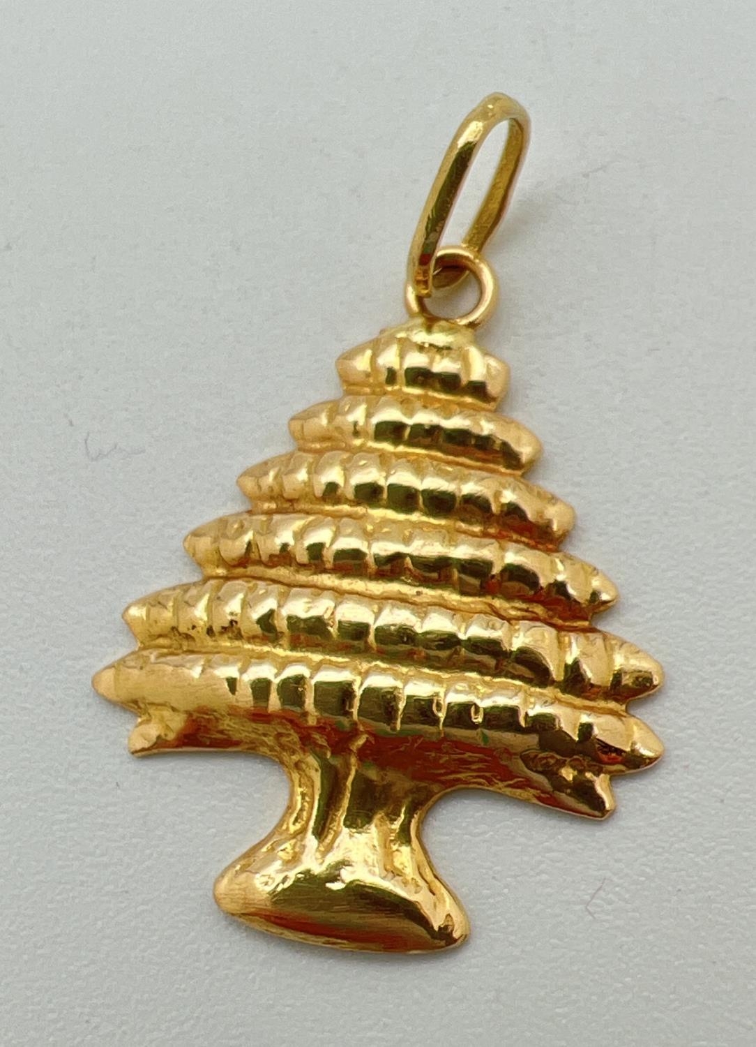 An 18ct gold pendant in the shape of a tree. Gold mark to hanging bale. Approx. 3cm x 2cm (including