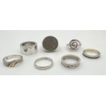 7 silver rings mostly in a band style. Lot includes a 1967 sixpence set in a vintage silver ring and