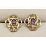 A pair of gold pierced work Celtic design stud earrings set with a small round cut amethysts. Gold