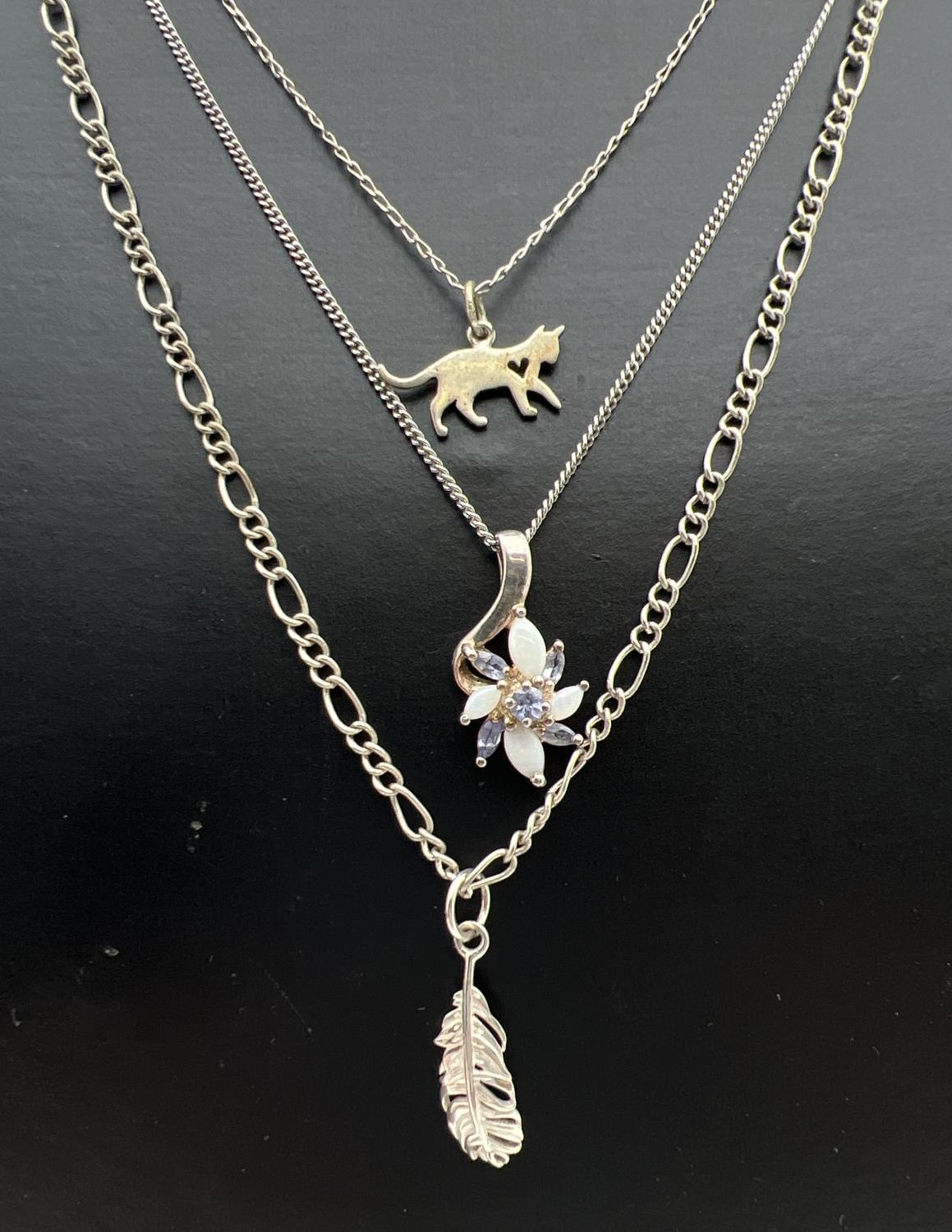 3 silver pendant necklaces. A cat pendant on a 20" fine belcher chain, a feather pendant on a 20"