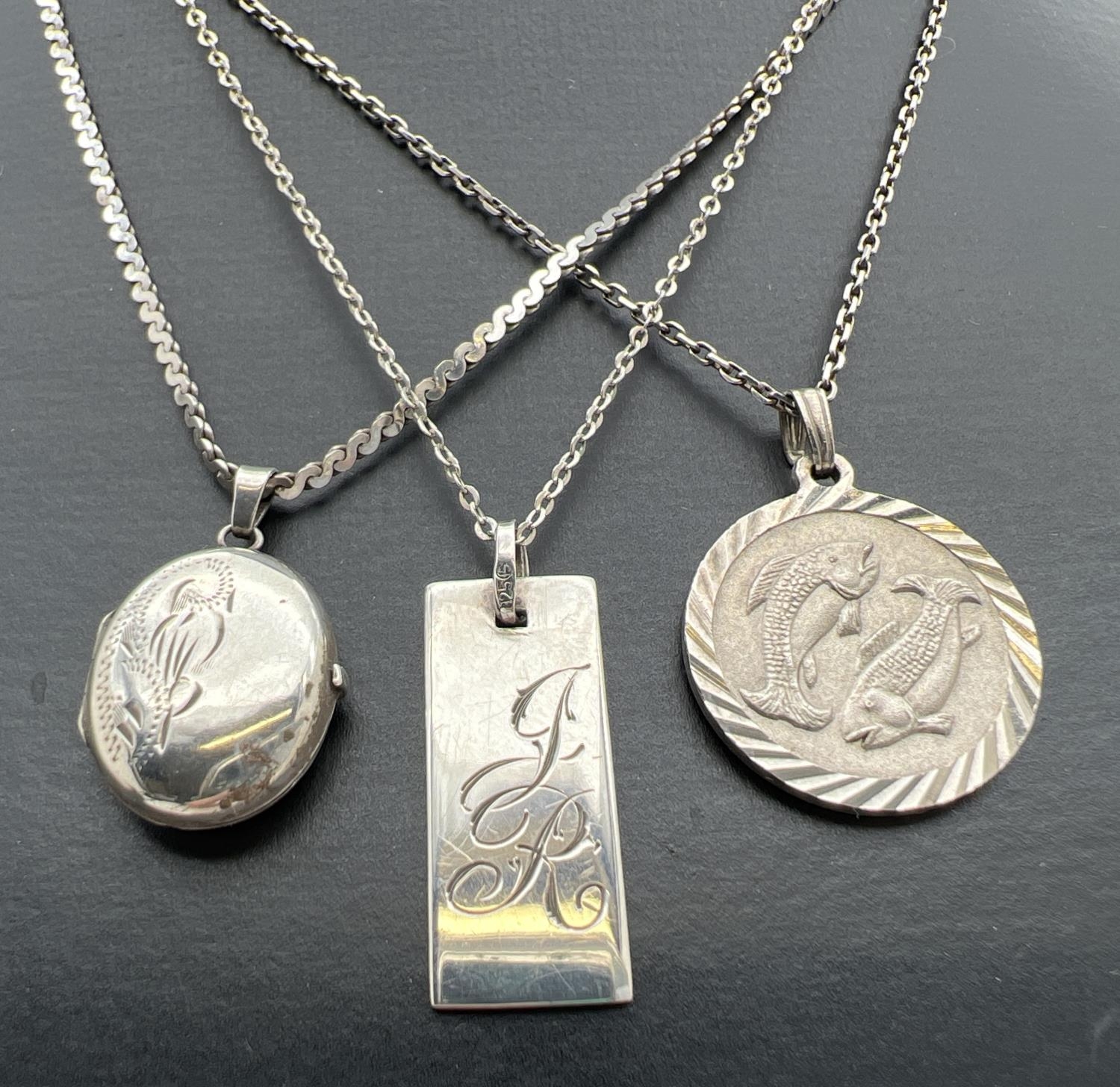 3 silver and white metal pendant necklaces. A circular shaped Pisces white metal pendant on a silver