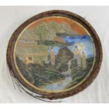 A large Oriental hand painted plate with wicker weaved frame (a/f). Blue & white painted detail to
