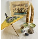 A box of assorted Oriental items to include a pair of resin carved horn ornaments, Egyptian papyrus,