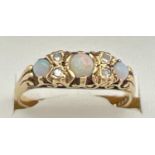 A Victorian style 18ct gold opal and diamond gypsy dress ring with pierced scroll design mount. Ring