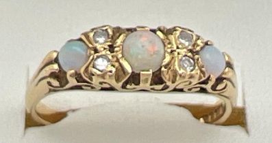 A Victorian style 18ct gold opal and diamond gypsy dress ring with pierced scroll design mount. Ring