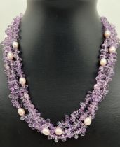 A cased 16" amethyst and pink lustre multi strand necklace with 14ct gold fish hook clasp.