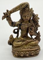 A miniature gilt bronze figurine of an Oriental diety, approx. 4cm tall.