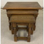 A vintage solid oak nest of 3 tables with turned design splayed legs. Approx. 45cm tall x 60cm long.