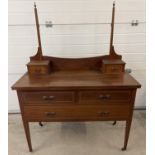 An Edwardian satin wood dressing table with inlaid detial and tapered legs raised on ceramic