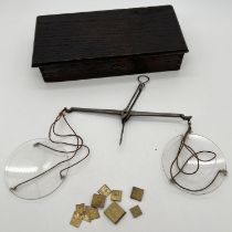 A vintage wooden boxed set of glass dish opium scales with various square small brass weights