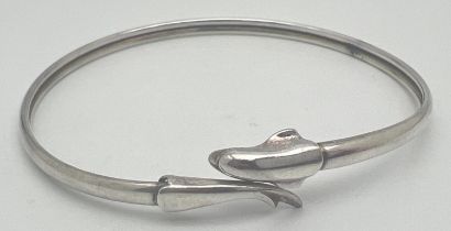 An adjustable silver bangle with dolphin detail. Marked Silver to inside. Approx. 7cm diameter.