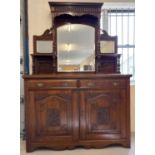 An Edwardian dark oak mirror backed side board with decorative carved columns and panelled detail.