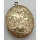 A yellow metal (front and back) oval locket with floral decoration to front and foliate & scroll