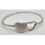 A modern design double heart silver bangle with hook clasp. Central brushed silver and open work