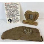 3 items of militaria. A reproduction Mussolini ceramic tile, an army side cap with The Gordon