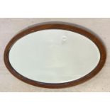 A vintage oval wooden framed bevel edge mirror with inlay detail to frame. Approx. 73 x 42.5cm.