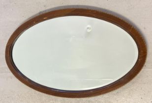 A vintage oval wooden framed bevel edge mirror with inlay detail to frame. Approx. 73 x 42.5cm.