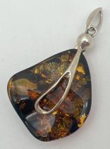 A large contemporary design silver and amber pendant. Teardrop shaped overlay detail to front with