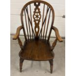 A vintage wheel backed elm wood Windsor armchair with spindled back and turned legs and arm